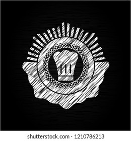 chef hat icon inside chalk emblem written on a blackboard