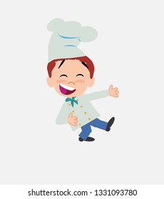 Chef laughing while teaching something to his left.