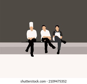 Chefs in uniform with aprons taking a break after hard work at work place copy space. in restaurant kitchen