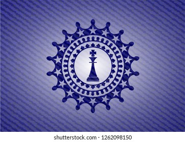 chess king icon inside badge with denim background