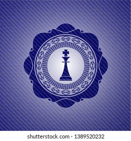chess king icon inside badge with denim background