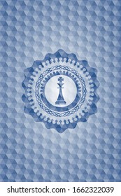 icono del rey del ajedrez dentro de la placa azul con motivos geométricos.