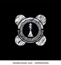 chess king icon inside chalk emblem written on a blackboard