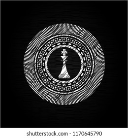 chess king icon inside chalkboard emblem on black board