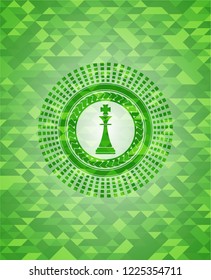 chess king icon inside green mosaic emblem