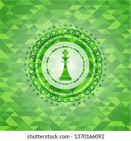 chess king icon inside green emblem with triangle mosaic background