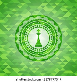 chess king icon inside green emblem. Mosaic background. 