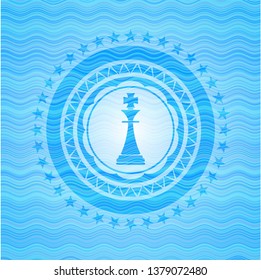 chess king icon inside light blue water wave badge background.