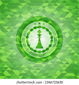 chess king icon inside realistic green emblem. Mosaic background