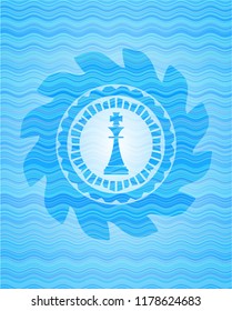 chess king icon inside water wave style badge.