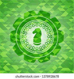chess knight icon inside green emblem with triangle mosaic background