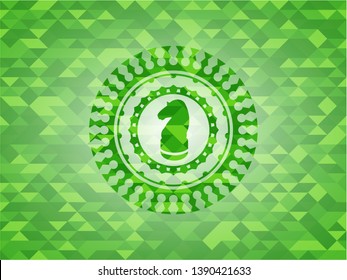 chess knight icon inside green mosaic emblem