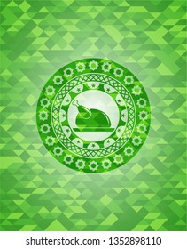 chicken dish icon inside green mosaic emblem