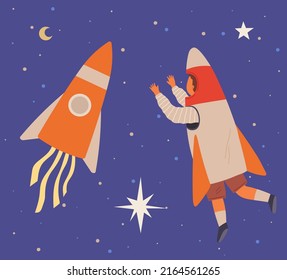 Child astronaut in cardboard or plastic rocket outfit dreams about space. Creative boy in self made costume imagines flying in sky. Kid playing space explorer. Guy in costume near huge rocket