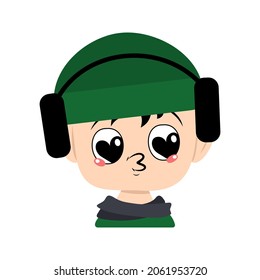 Child with big heart eyes and kiss lips in green hat with headphones. Cute kid with loving face in autumnal or winter headdress and scarf. Adorable baby with emotions