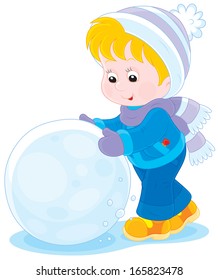 Child with a big snowball for a snowman