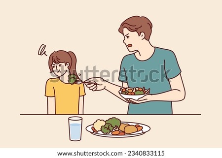 Child does not want to eat salad and green vegetables standing near father trying to teach daughter eat healthy food. Stubborn teenage girl refuses healthy vegetables and turns away.