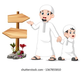 a child with his father is standing and posing near the blank wooden signpost