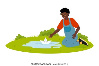 Child playing with paper boat in a small pond during a sunny afternoon in a green park