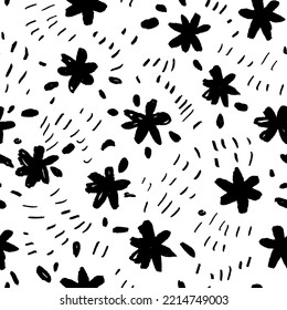 Childish style flowers seamless pattern with tiny dots. Brush drawn black floral silhouettes. Graphic sketch drawing of small daisies, simple chamomiles with leaves. Black ink illustration.
