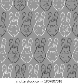 Children drawing rabbits hand drawn wax crayons art on grey.Chalk Easter bunny background.  Crayon style funny bunny backdrop. Color oil pastel crayons freehand drawn rabbits. Fabric Easter texture.
