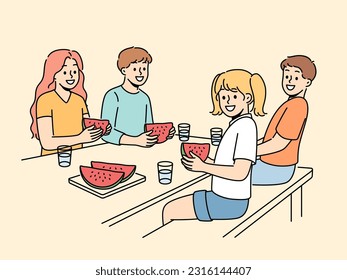 Children eat watermelon sitting at table and enjoying sweet refreshing dessert on hot summer day. Childrens picnic for boys and girls with delicious watermelon containing healthy vitamins