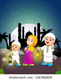 the children are holding the Ramadan lantern under the moonlight