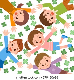 Children lying in clover with heads together.