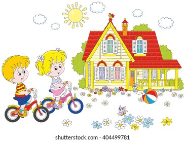 Children riding bicycles on a sunny summer day near a country house