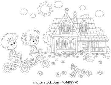 Children riding bicycles on a sunny summer day near a country house