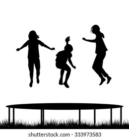 Children silhouettes jumping on garden trampoline