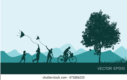 Children silhouettes play with kites and cyclists at sunset.