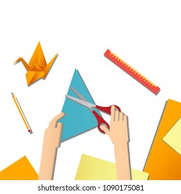 Children's hands do origami from colored paper on white background. lesson of origami