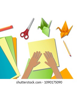 Children's hands do origami from colored paper on white background. lesson of origami