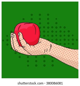 Child's hand holding red apple on green background in pop art style