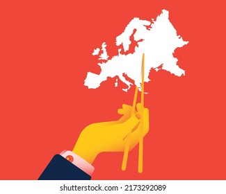 Chinese hand holds the outline of Europe with Chinese chopsticks. The concept of Europe and China relations, China's power over Europe, and bad international relations.