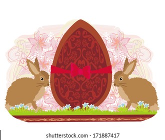 chocolate egg with red bow and two beautiful rabbits