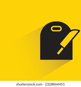 chopping board and knife shadow on yellow background