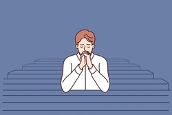 Christian Man Sits And Prays In Catholic Church, Turning To God To Confess Or Ask For Help. Believing Guy In Church And Prays To Feel Psychological Relief Or Observe Religious Ritual 