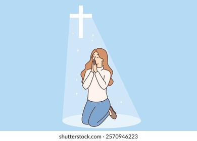 Christian woman prays on knees under religious crucifix or cross emitting bright light. Orthodox or catholic girl prays and turns to lord to ask to atone for sins and avoid going in hell.