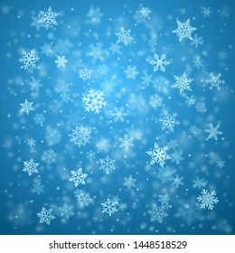 Christmas background of complex blurred and clear falling snowflakes in light blue colors with bokeh effect