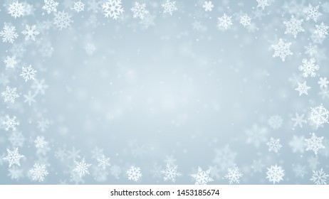 Christmas background of complex blurred and clear falling snowflakes in light blue colors with bokeh effect