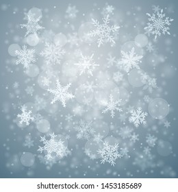 Christmas background of complex blurred and clear falling snowflakes in light blue colors with bokeh effect