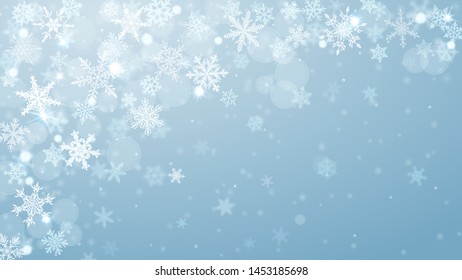 Christmas background of complex blurred and clear falling snowflakes in light blue colors with bokeh effect