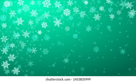 Christmas background of complex blurred and clear falling snowflakes in turquoise colors with bokeh effect