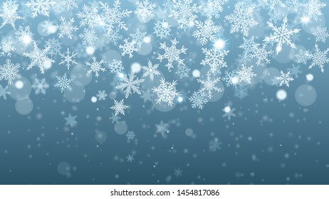 Christmas background of complex blurred and clear falling snowflakes in light blue colors with bokeh effect