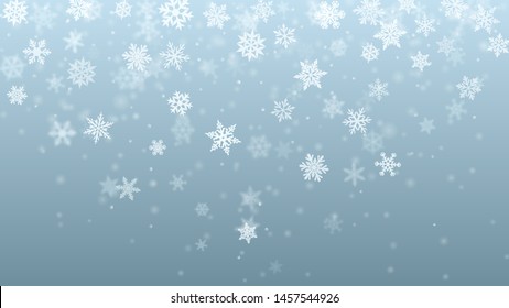 Christmas background of complex blurred and clear falling snowflakes in light blue colors with bokeh effect