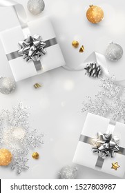 Christmas background. Festive bright design composition top view. Decoration gift box, silver balls, decorative snowflake in glitter. Xmas bauble, white silk ribbon and candy