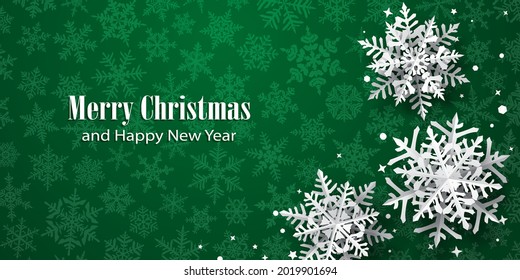 Christmas background of paper snowflakes with soft shadows, white on green background with falling snow