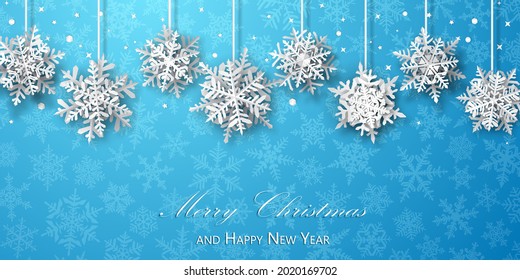 Christmas background of paper snowflakes with soft shadows, white on light blue background with falling snow